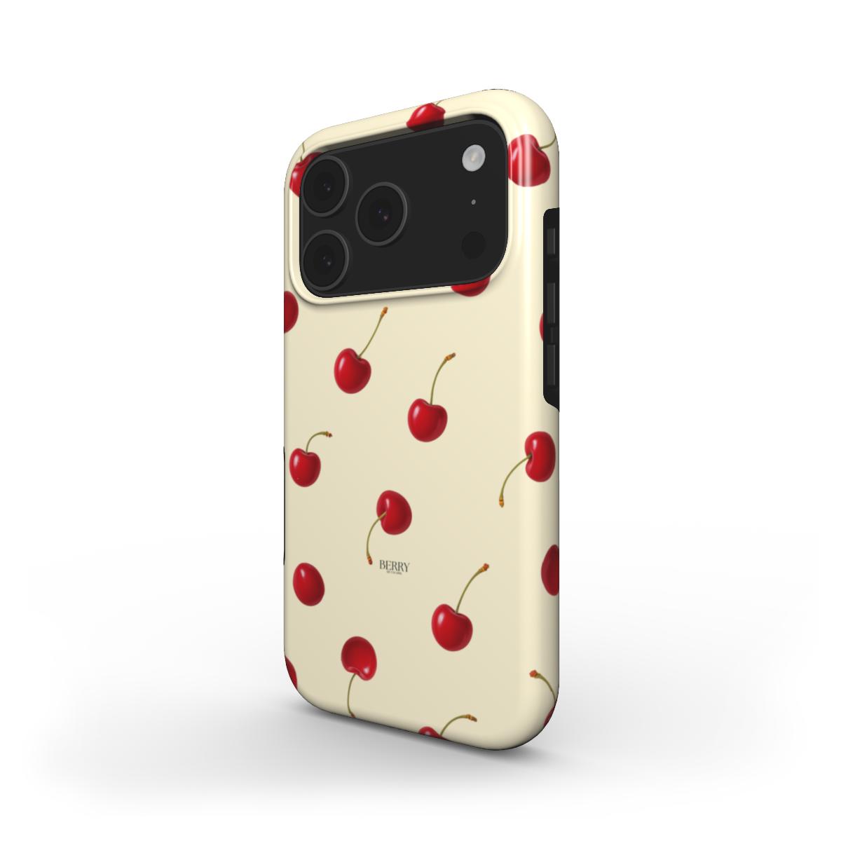 Trendy phone case with a vibrant cherry pattern in red and multicolor on a soft creamy yellow background, perfect for a stylish, girly look.