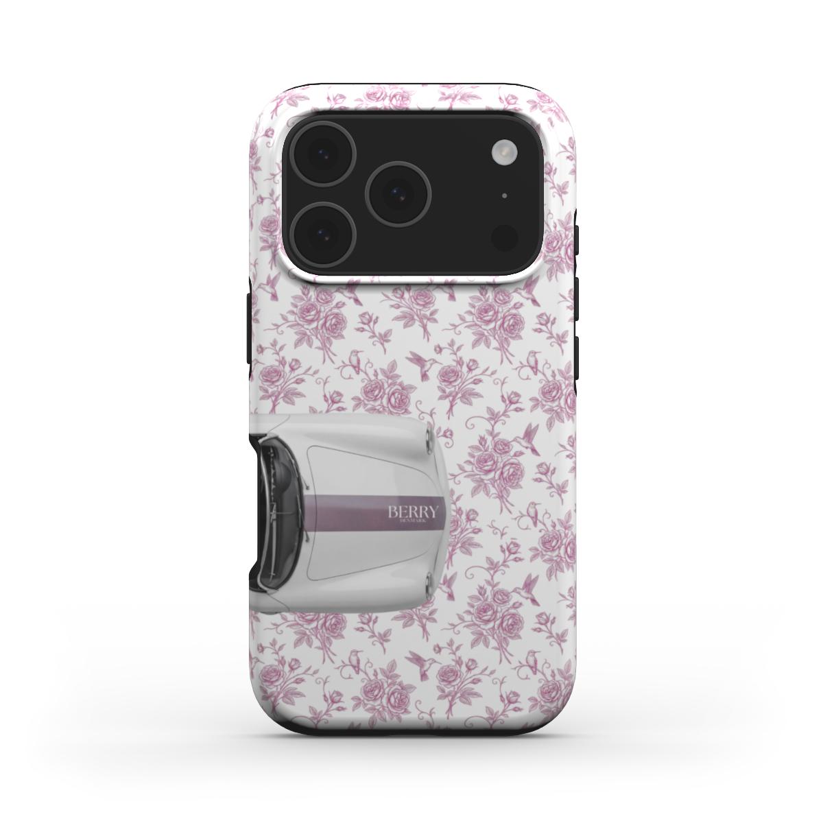 Trendy phone case with a feminine pink floral pattern and a stylish silver convertible car detail, perfect for a girly and aesthetic look.