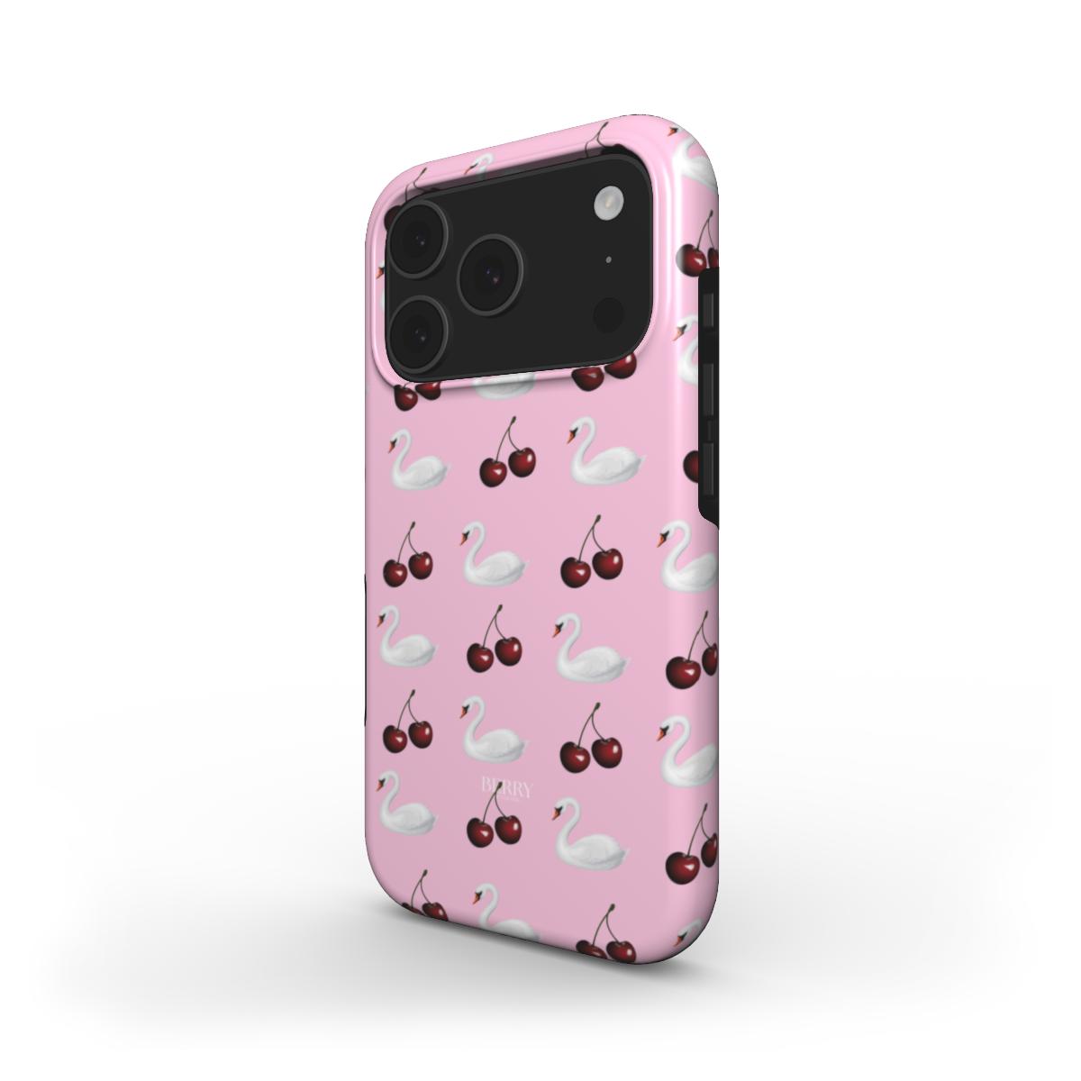 Trendy pink phone case featuring a playful pattern of white swans and bright cherries, perfect for a feminine and stylish look.