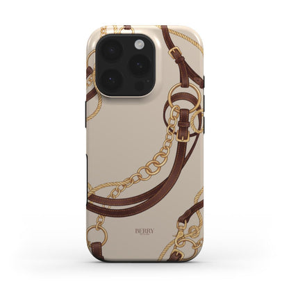Trendy phone case with a feminine equestrian design featuring multicolored gold, brown, and beige chains and leather straps on a chic background.