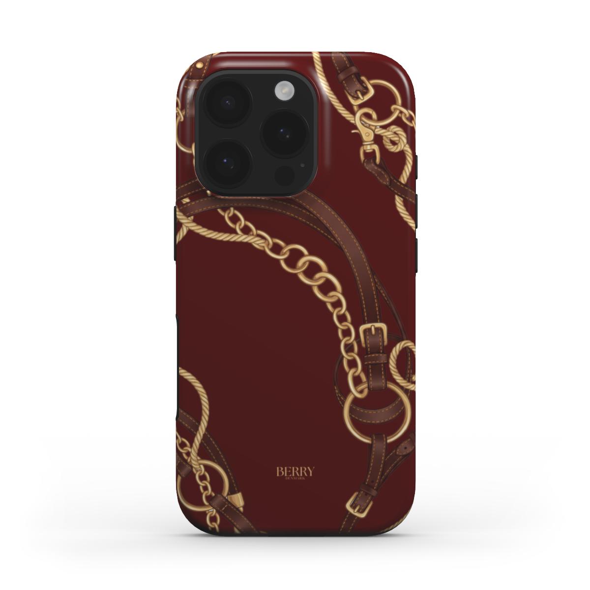 Trendy burgundy phone case with elegant gold chain and brown equestrian strap design, combining feminine and popular aesthetic for a beautiful look.